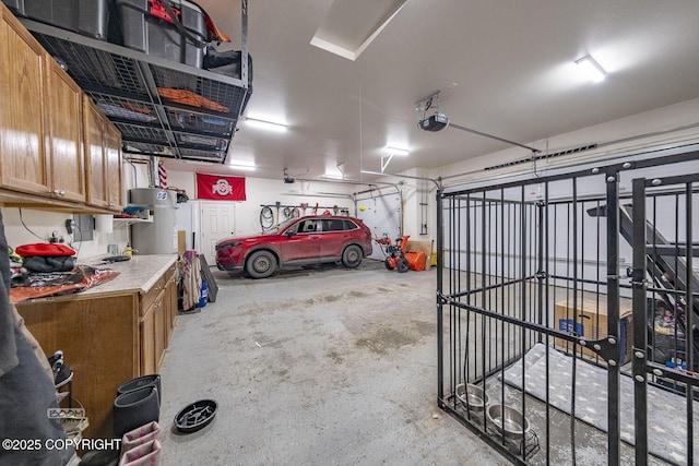 garage featuring a garage door opener and secured water heater