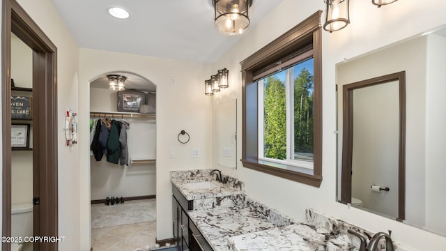 bathroom with vanity, plenty of natural light, tile patterned floors, and toilet