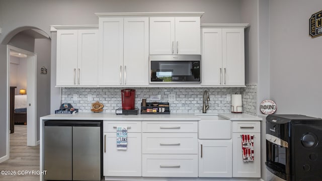 kitchen featuring appliances with stainless steel finishes, decorative backsplash, and white cabinets