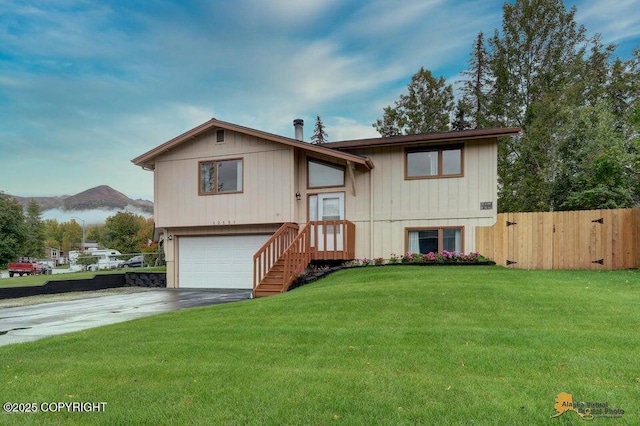 split foyer home with a mountain view, a garage, and a front lawn