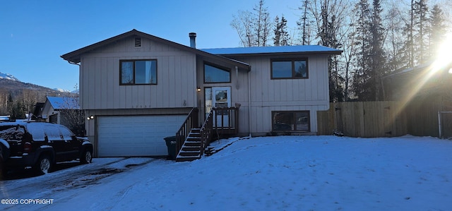 bi-level home featuring a garage and a mountain view