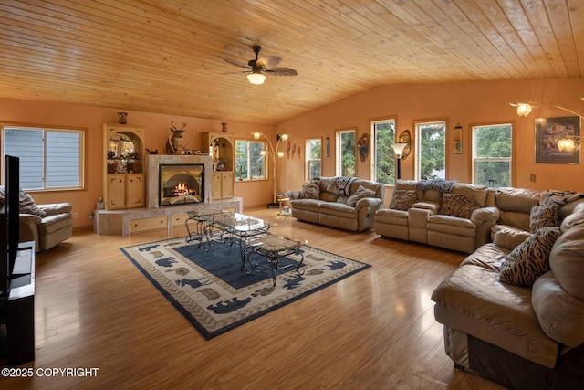 living room with a tiled fireplace, vaulted ceiling, wood ceiling, and light hardwood / wood-style flooring