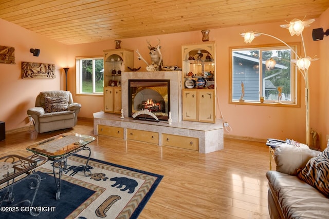 living room featuring wood ceiling, a high end fireplace, and light hardwood / wood-style floors