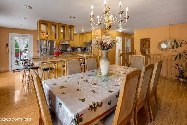 dining space featuring a notable chandelier and light wood-type flooring