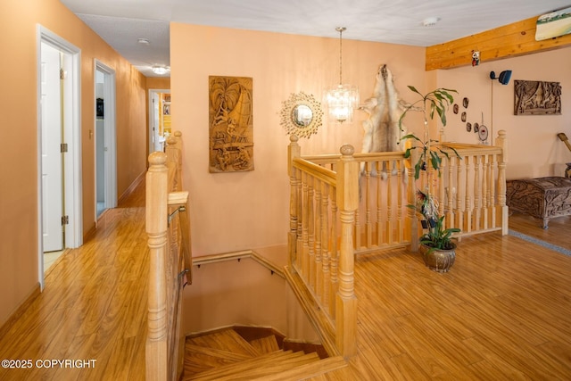 stairway featuring hardwood / wood-style flooring and a chandelier