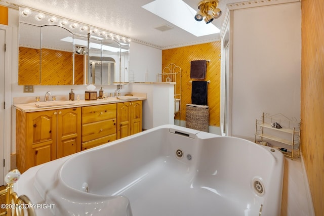 bathroom featuring a tub to relax in, a skylight, vanity, and wood walls