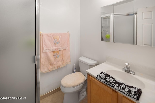 bathroom featuring vanity, a shower with door, and toilet