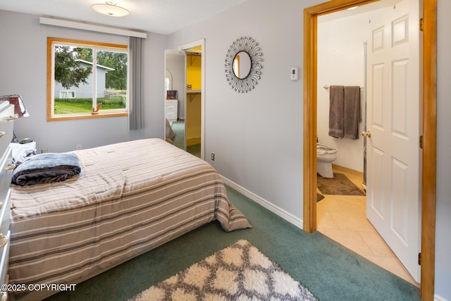 bedroom with tile patterned flooring and connected bathroom