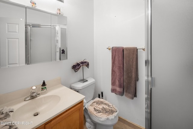 bathroom with vanity, toilet, and a shower with shower door