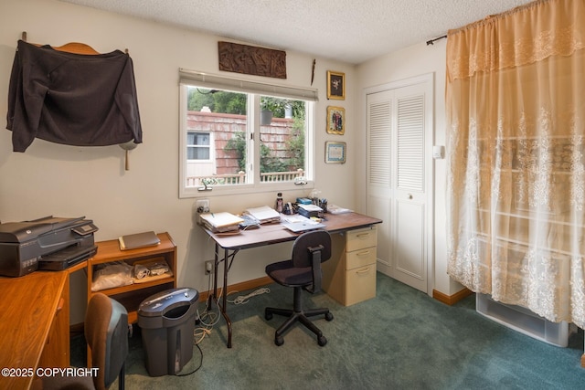 carpeted home office featuring a textured ceiling