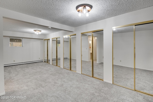 basement featuring carpet floors, a textured ceiling, and a baseboard heating unit