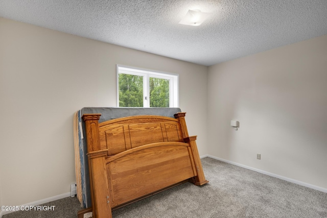 bedroom featuring a textured ceiling and carpet flooring