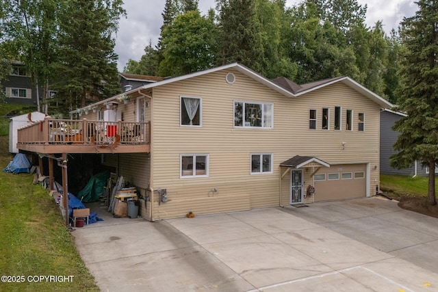 rear view of house featuring a garage and a wooden deck