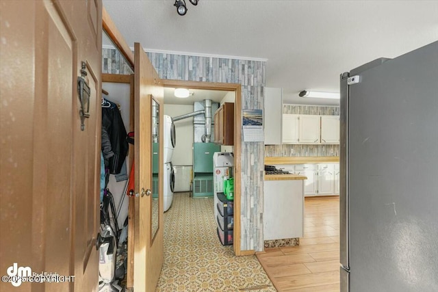 interior space with stainless steel refrigerator, white cabinetry, and light hardwood / wood-style floors