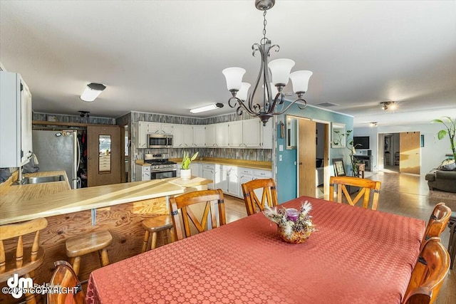 dining space featuring sink and a notable chandelier