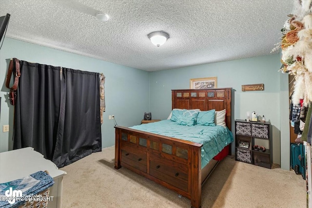 bedroom featuring light carpet and a textured ceiling