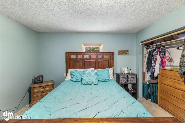 carpeted bedroom with a textured ceiling and a closet