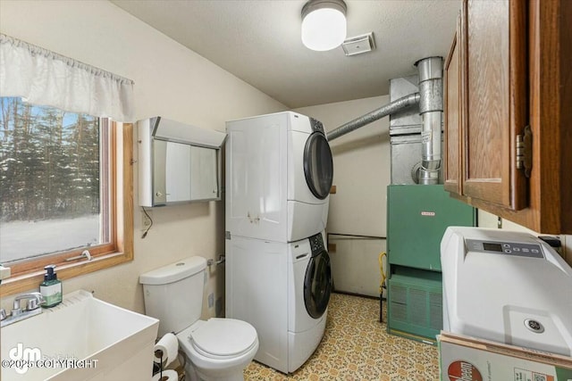 laundry room with sink and stacked washer and clothes dryer