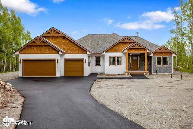 view of front of house featuring aphalt driveway, an attached garage, and a shingled roof