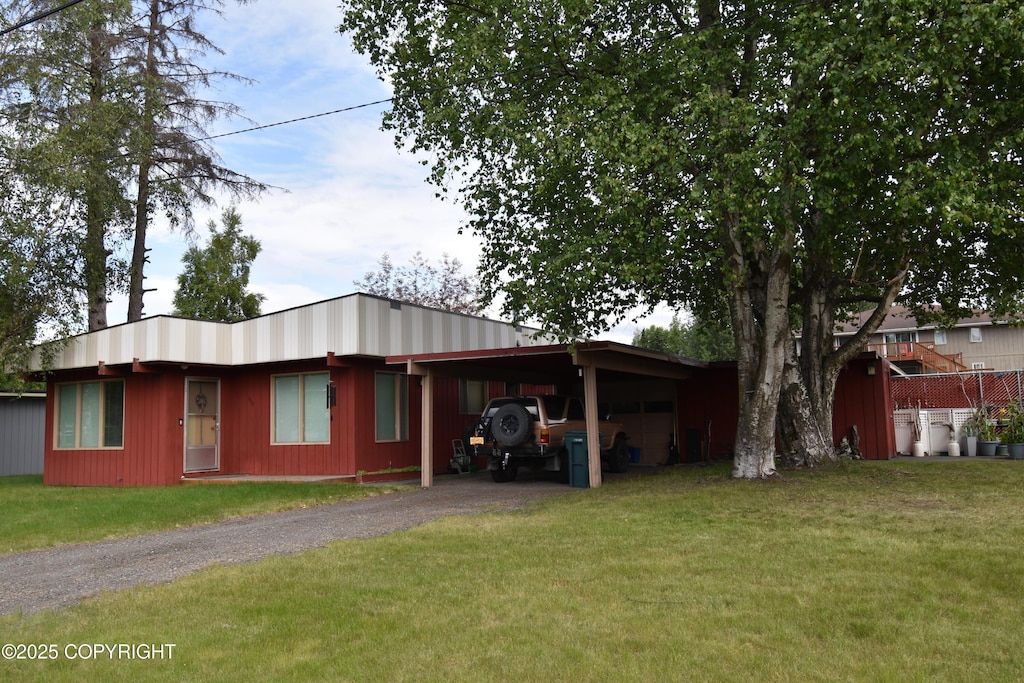 view of side of property featuring a carport and a lawn