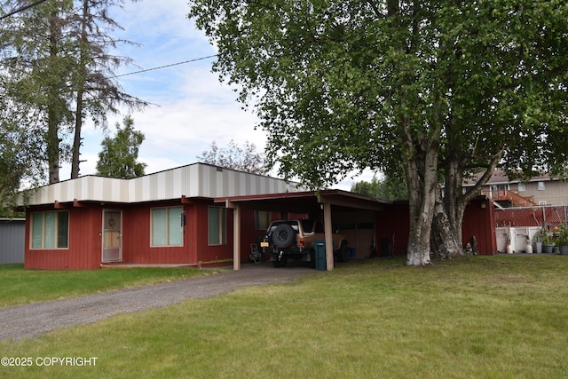 view of side of property featuring a carport and a lawn