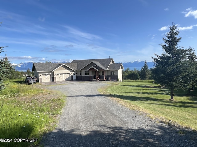 view of front of home featuring a mountain view, a garage, and a front lawn