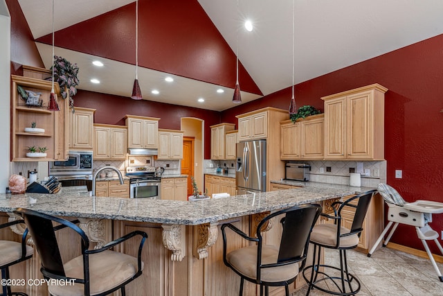 kitchen featuring a breakfast bar area, kitchen peninsula, pendant lighting, stainless steel appliances, and light stone countertops