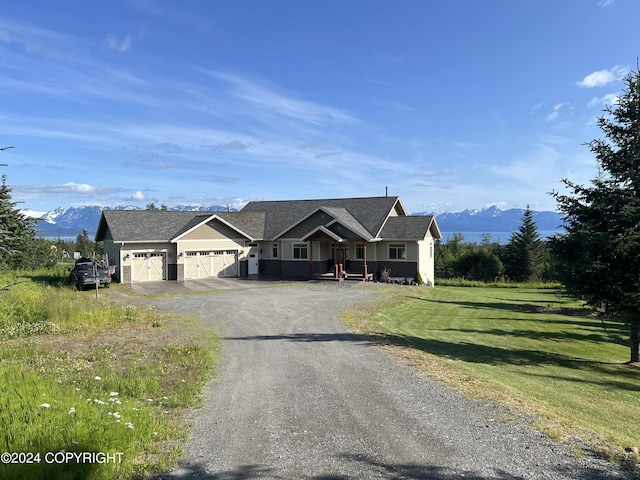 view of front of home featuring a mountain view, a garage, and a front yard