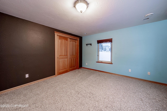 unfurnished bedroom featuring carpet, a closet, and a textured ceiling