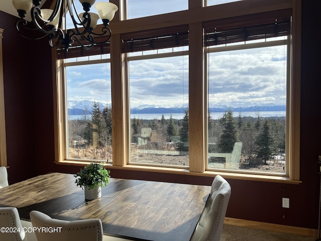 tiled dining space with a mountain view, plenty of natural light, and a notable chandelier