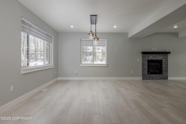 unfurnished living room with a fireplace and light hardwood / wood-style floors