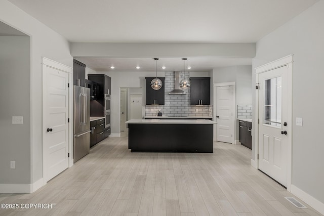 kitchen with a center island, wall chimney range hood, pendant lighting, stainless steel appliances, and backsplash