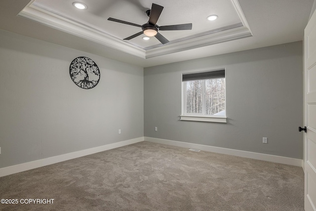 spare room with light carpet, crown molding, and a raised ceiling