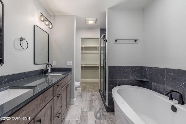 full bathroom featuring vanity, toilet, and separate shower and tub