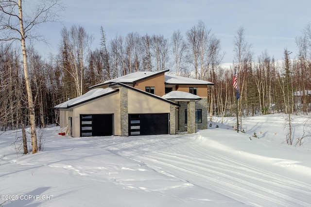 snow covered property with a garage