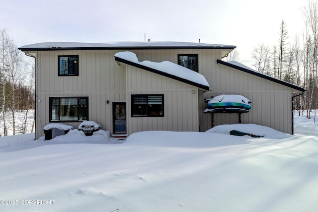 view of snow covered rear of property