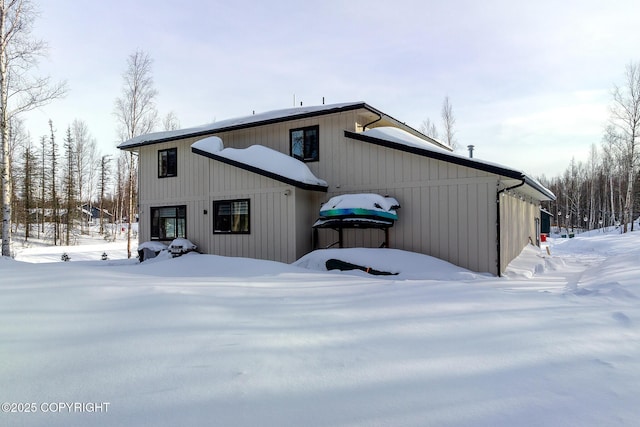 view of snow covered back of property