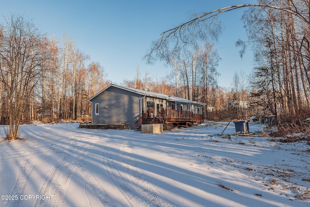 snow covered house with a wooden deck