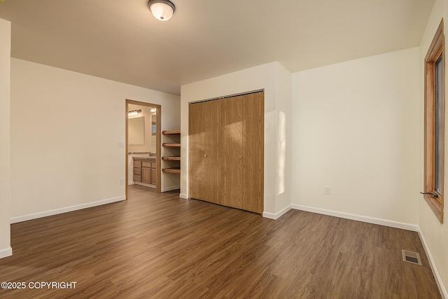 unfurnished bedroom with dark hardwood / wood-style floors and a closet