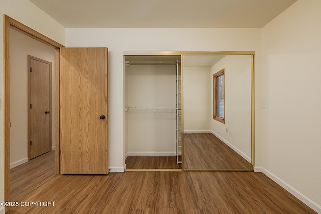 unfurnished bedroom featuring hardwood / wood-style floors and a closet