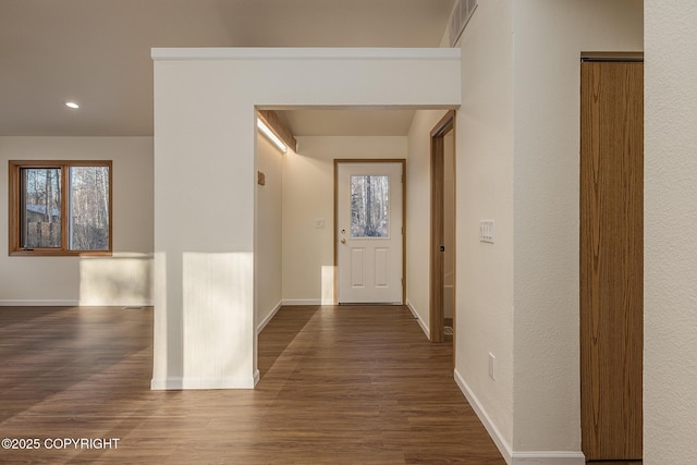 hall featuring plenty of natural light and dark hardwood / wood-style floors