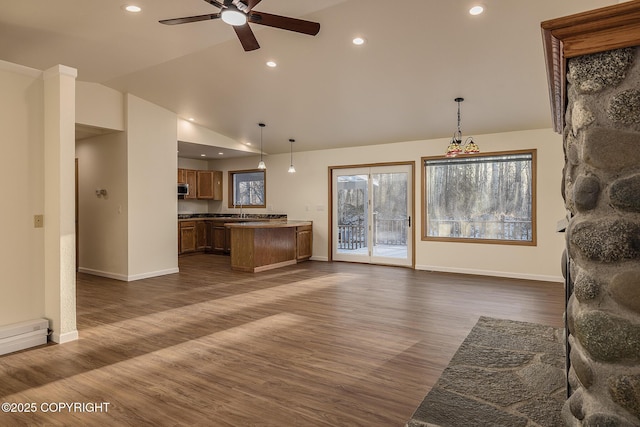 living room featuring sink, dark wood-type flooring, ceiling fan, a baseboard radiator, and vaulted ceiling