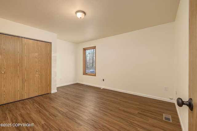 unfurnished bedroom featuring dark hardwood / wood-style floors and a closet