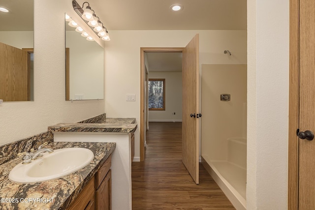 bathroom with vanity, hardwood / wood-style flooring, and walk in shower