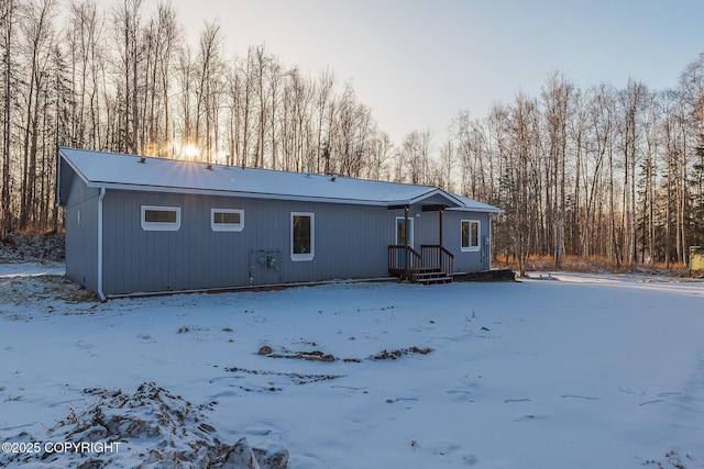 view of snow covered back of property