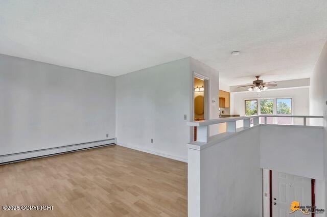 7750 Boundary Ave # A3, Anchorage, AK 99504 - spare room featuring baseboard heating, wood finished floors, and a ceiling fan
