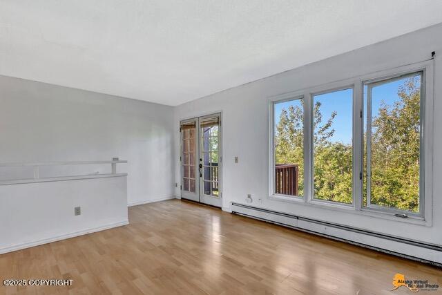 7750 Boundary Ave # A3, Anchorage, AK 99504 - empty room featuring baseboard heating and wood finished floors