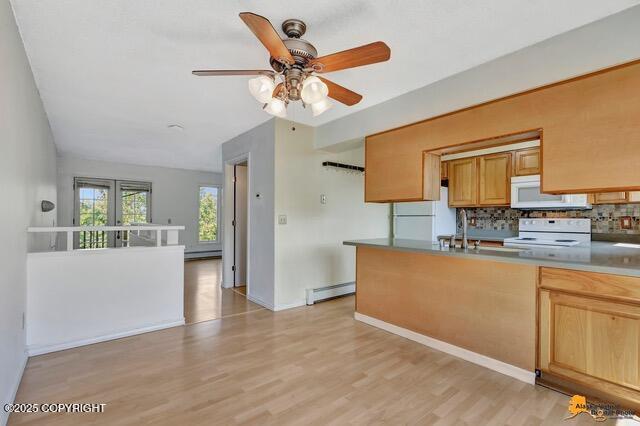 7750 Boundary Ave # A3, Anchorage, AK 99504 - kitchen featuring white appliances, a ceiling fan, decorative backsplash, a baseboard heating unit, and light wood-style flooring