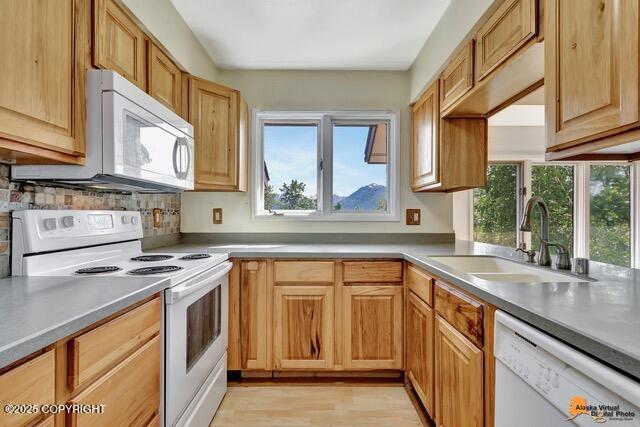 7750 Boundary Ave # A3, Anchorage, AK 99504 - kitchen featuring white appliances, light wood-style floors, and backsplash