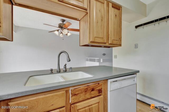 7750 Boundary Ave # A3, Anchorage, AK 99504 - kitchen with white dishwasher, a baseboard heating unit, ceiling fan, and light brown cabinetry